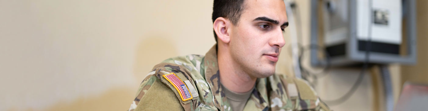 Soldier working attentively at computer