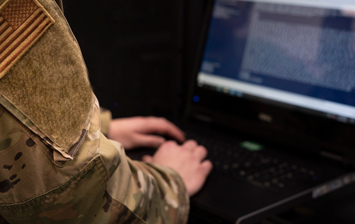 Soldier typing on laptop